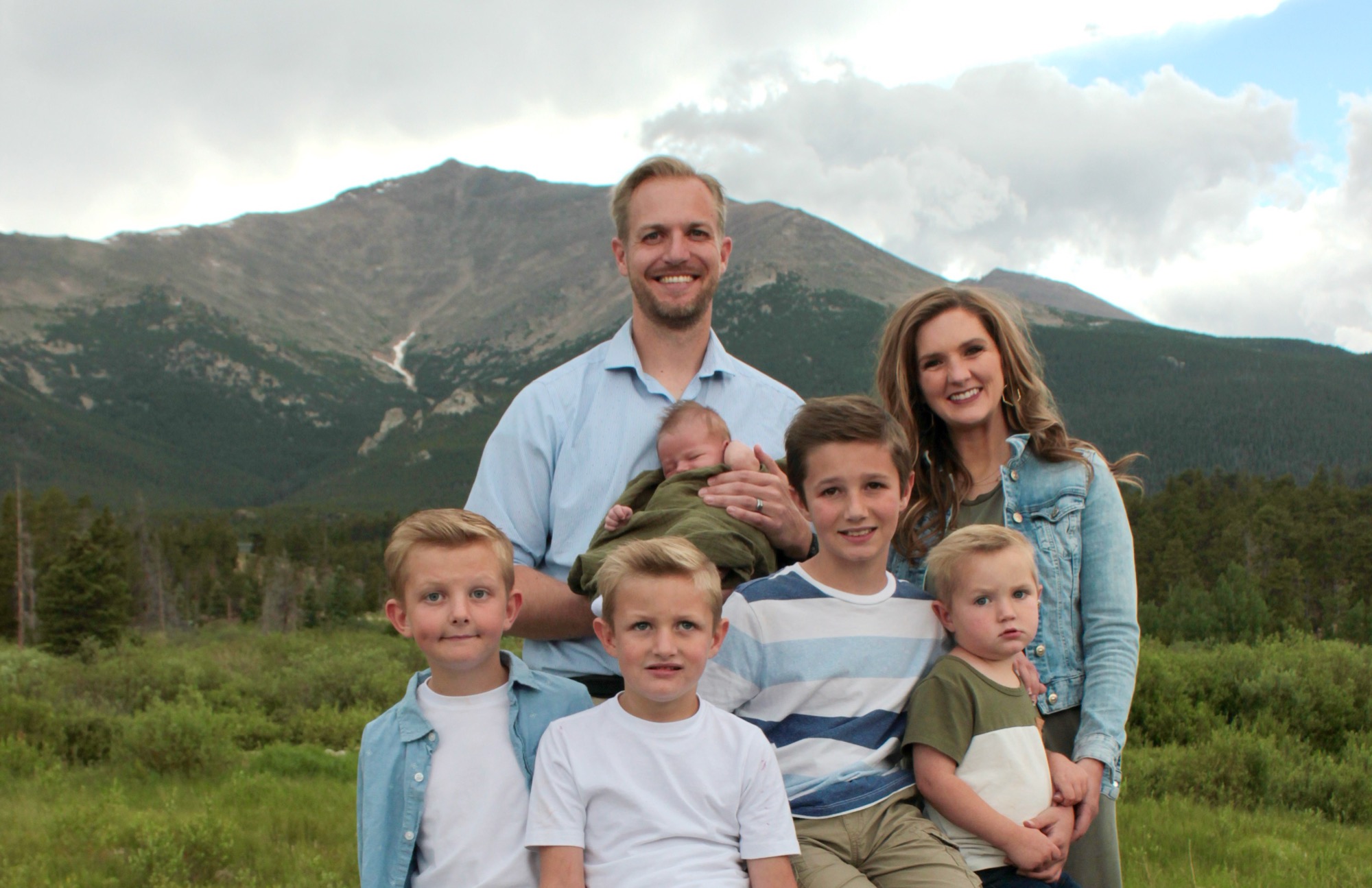 The Evans family together in front of a mountain peak